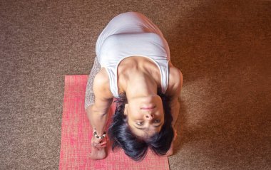 Yoga egzersiz yaparak asana oturan 40 haftalık hamile orta yaşlı beyaz kadın. Üstten Görünüm, koyu renkli. Thunderbolt poz.