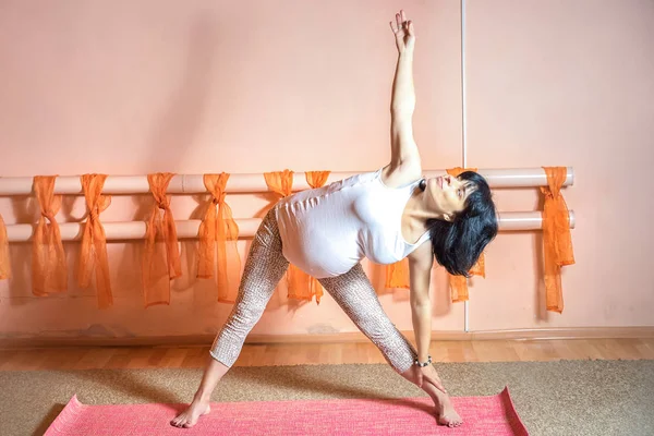 Concepto de estilo de vida saludable de maternidad. 40 semanas de embarazo mujer caucásica de mediana edad haciendo ejercicios de yoga Utthita Trikonasana o postura triangular . — Foto de Stock