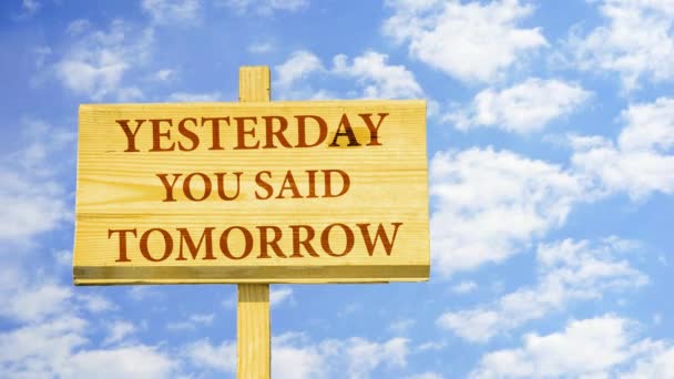 Yesterday you said tomorrow. Words on a wooden sign against time lapse clouds in the blue sky. — Stock Video
