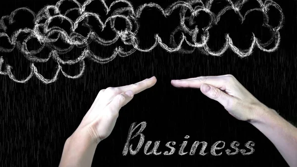 Hands protects business from the elements - rain or storm. Chalk drawing on the blackboard and human arms. — Stock Photo, Image