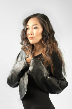 siyah deri ceketli kıvırcık saçlı güzel bir Asyalı kadın portresi