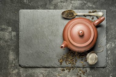 Geleneksel Çince çaydanlık siyah çimento arka plan üzerinde duran siyah bir taş tepsi bira yeşil çay ile. Metniniz için kopya alanı ile Üstten Görünüm.