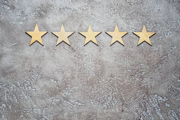 Five Wooden Stars Arranged Row Neutral Beige Textured Cement Background — Stock Photo, Image