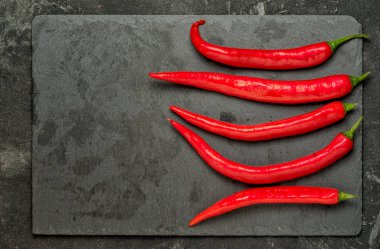 Kırmızı sıcak biber siyah üzerine döşeme siyah taş üçgen tepsi üzerinde arka plan, kopya alanı ile üst ciew çimento