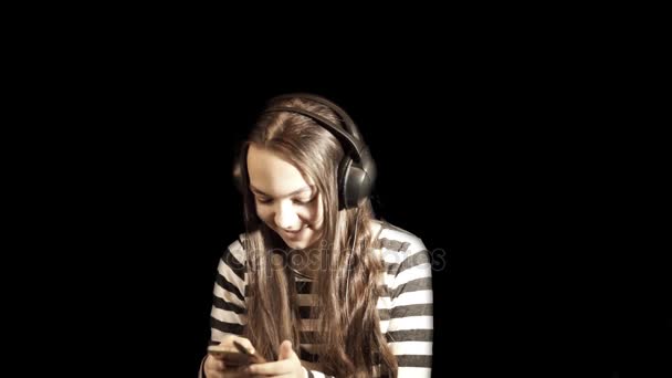 Nastolatek Dziewczyna Słucha Muzyki Słuchawkach Gesty Taniec Czarnym Tle Portret — Wideo stockowe