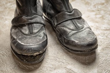 Eski siyah deri çizme bej çimento zemin üzerine yakın çekim uyarıyorlar