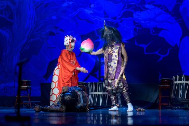 Geleneksel Japon gösterisi. Geleneksel kostümlü oyuncular sahnede gösteri yaparlar. Ölü samuray yatar ve kadın iblisle konuşur..