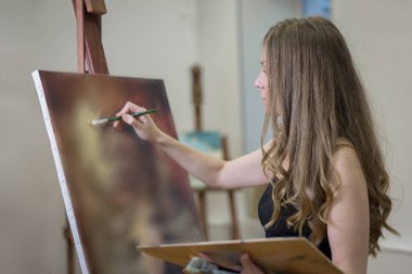 Sanat stüdyosundaki sanatçı çelik tezgahına soyut bir portre çiziyor..