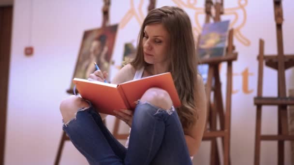 Γυναίκα Καλλιτέχνης Ζωγραφίζει Ένα Σημειωματάριο Χαρτί — Αρχείο Βίντεο