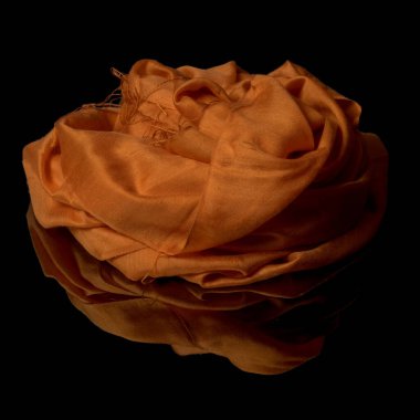 Turuncu dalgalı ipek kumaş şal, buruşuk kumaş girdap gül şekli, siyah arkaplanda izole edilmiş, yansıması olan..