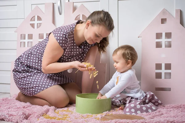 Mamá Muestra Pasta Hija Año Sentada Suelo Jugando — Foto de Stock