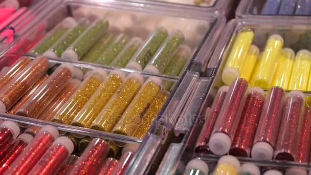 Colored sequinsin tubes for makeup. Shiny glitter on makeup. — Stock Video