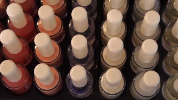 Muchas botellas de esmalte de uñas de colores . — Vídeos de Stock