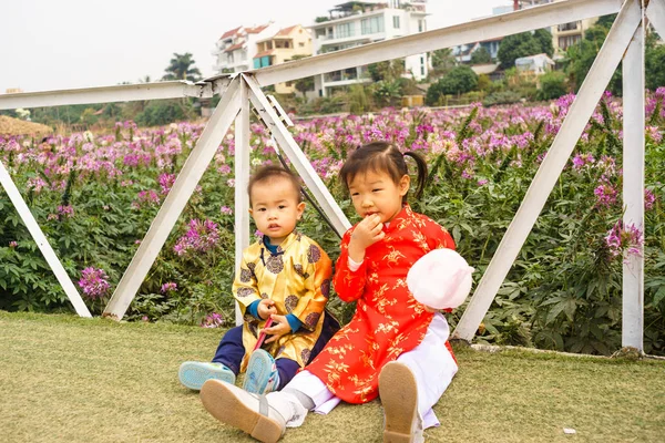 Vietnamese kids are eating cake in a roses garden — Stock Photo, Image