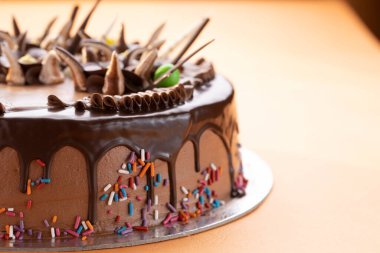 Çikolata ezmeli pasta üzerine çikolata ve beyaz çikolata çubuğu ve çırpılmış krema.