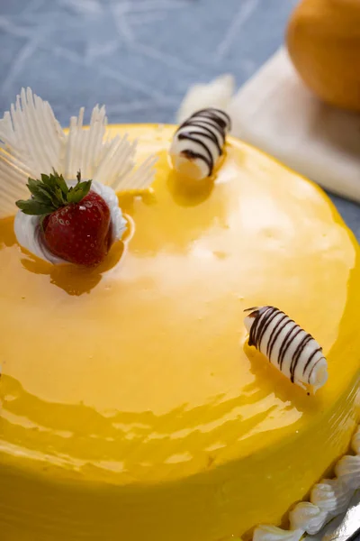 Mango mouse cake decorated with two mangoes
