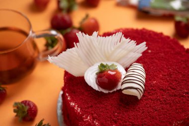 Çilekli pasta turuncu masa paspasının üstüne yerleştirilmiş.