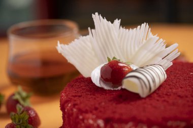 Çilekli pasta turuncu masa paspasının üstüne yerleştirilmiş.