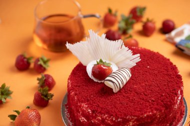 Çilekli pasta turuncu masa paspasının üstüne yerleştirilmiş.