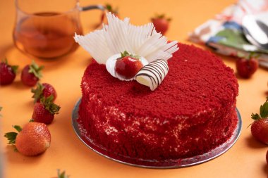 Çilekli pasta turuncu masa paspasının üstüne yerleştirilmiş.