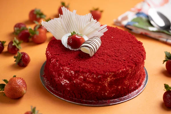 Çilekli pasta turuncu masa paspasının üstüne yerleştirilmiş.