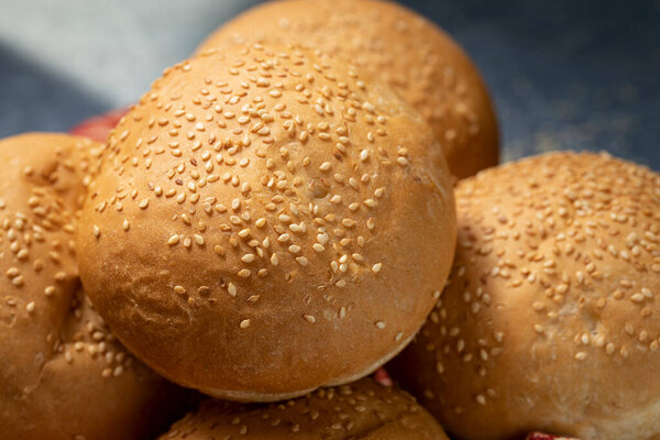 Кара засеяла булочки с бургером в корзине на синем столе, красная ткань
