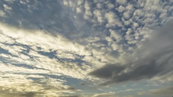 空の色が変わる夕方の黄色から藍へ。サークロコーム、アルトストラタス、アルトコームなどの異なる雲の層の動き. — ストック動画