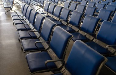 Havaalanının kalkış salonunda mavi sandalyeler, sandalye terminali.