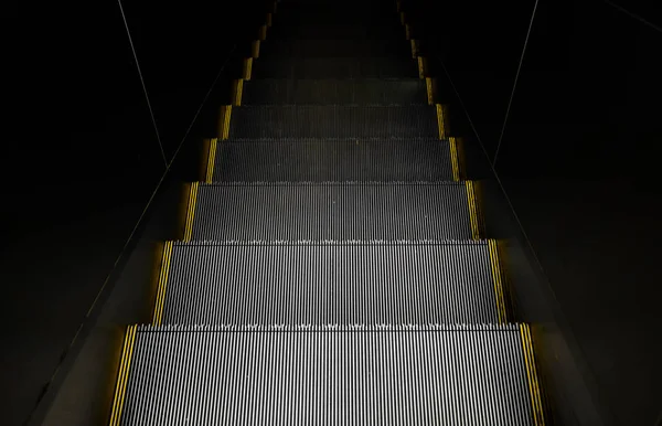Escada rolante em uma estação subterrânea visão de fundo escuro — Fotografia de Stock