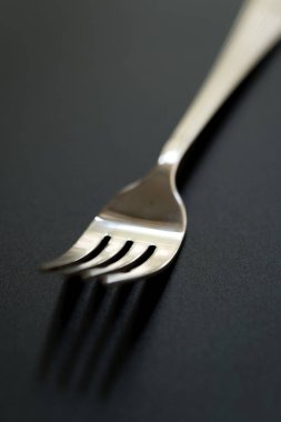 Siyah arka planda metal çatal. Kopyalama alanı olan paslanmaz çatalı kapat.