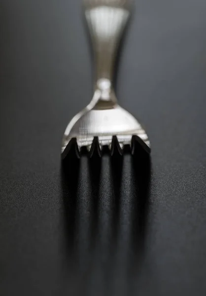 Tenedor de metal sobre fondo negro. Primer plano de la horquilla inoxidable con espacio para copiar . — Foto de Stock