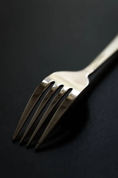 Fourchette en métal sur fond noir. Gros plan de la fourche en acier inoxydable avec espace de copie . — Photo