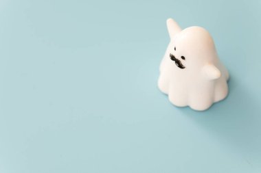 Mavi arkaplan görünümünde küçük beyaz renkli plastik hayalet figürü