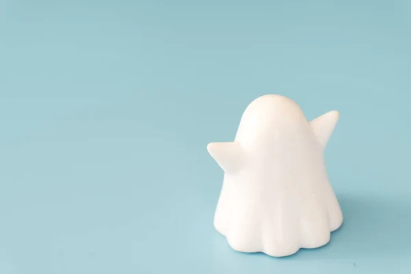Small white color plastic ghost figure in blue background view — 스톡 사진