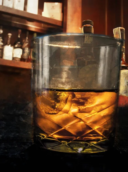 威士忌玻璃与其他瓶子背后 — 图库照片