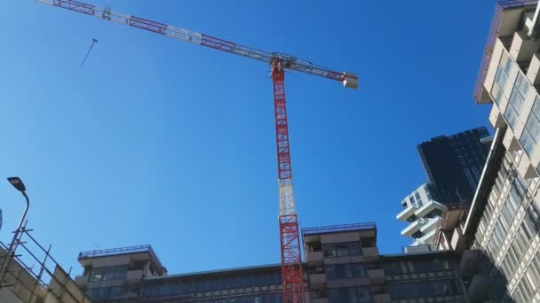 Trabalhos em curso para a construção de alguns edifícios. Vista de um guindaste — Vídeo de Stock