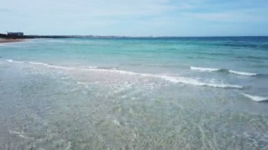 Kristal denizin dalgaları üzerinde uçan. Hava sinema görünümünü Gelibolu beach (İtalya - Puglia vurdu)