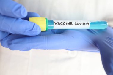 Coronavirus aşısı. Araştırma yapan bir bilim adamının elinde aşıyla test tüpü.