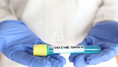 Coronavirus aşısı. Araştırma yapan bir bilim adamının elinde aşıyla test tüpü.