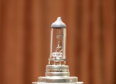 Burnt car light bulb on a brown background close-up