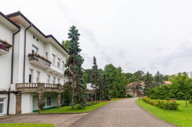 Banja Koviljaca, Sırbistan - 13 Temmuz 2019: Resmi parkta ağaçlar, çiçekler ve mimariyle güzel bir manzara, sağlık merkezinde bahçe Banja Koviljaca
