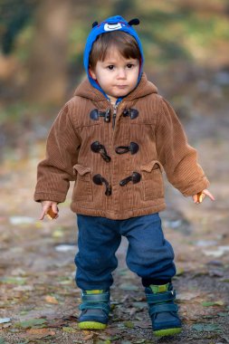 Küçük çocuk parkta bisküvi yiyor.