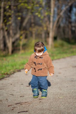 Sonbahar parkında duran küçük çocuk