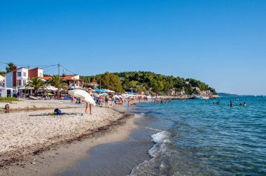 Halkidiki, Yunanistan - 30 Ağustos 2019: Siviri Golden Beach ve plaj turistleri. Yunanistan 'ın Halkidiki kentindeki Siviri' nin yeri. Ege Denizi üzerinde mavi deniz.