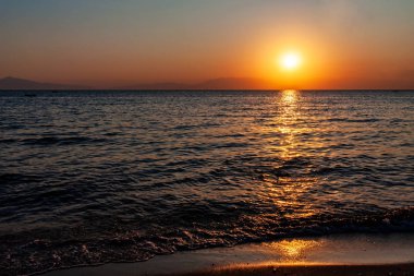 Deniz ve dağın üzerinde dramatik bir gün batımı. Fotoğraf: Halkidiki Yunanistan 'da Pirgo Sani.