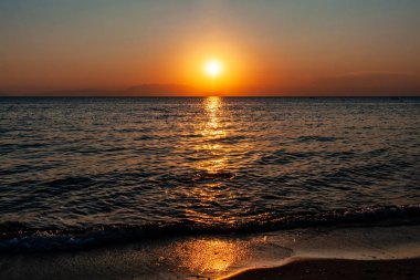 Deniz ve dağın üzerinde dramatik bir gün batımı. Fotoğraf: Halkidiki Yunanistan 'da Pirgo Sani.