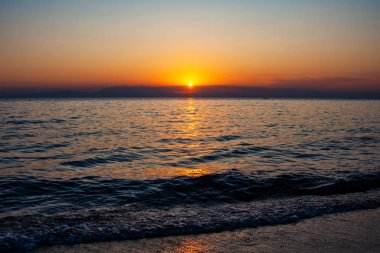 Deniz ve dağın üzerinde dramatik bir gün batımı. Fotoğraf: Halkidiki Yunanistan 'da Pirgo Sani.