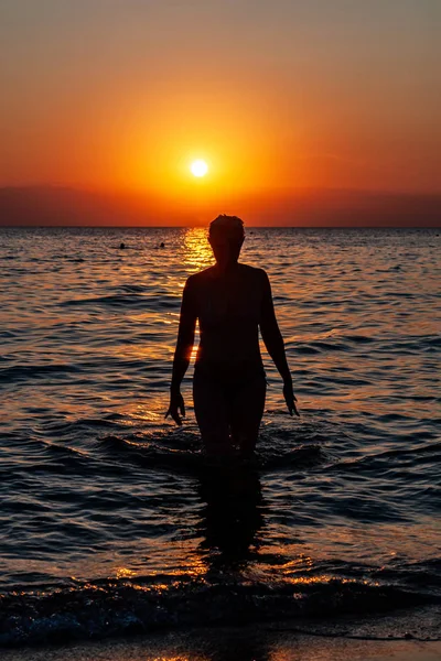Młoda Kobieta Spacerująca Wodzie Zachodzie Słońca Zachód Słońca Sylwetka Młodej — Zdjęcie stockowe