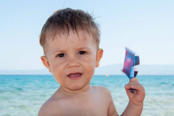 シャベルを持った少年が海岸で遊んでいる — ストック写真