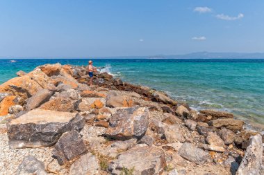 Halkidiki, Greece - September 05,2019: Lagoon Beach near Pefkochori, Halkidiki, Greece. An older man is fishing